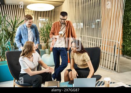 A diverse group of colleagues seated around a table, laptops open, engaged in a collaborative discussion on modern business strategies. Stock Photo