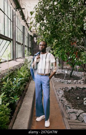 A sophisticated African American man standing confidently in front of a colorful building in a lush garden. Stock Photo