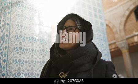 Smiling brunette woman with glasses in istanbul experiencing ottoman architecture at the topkapi palace. Stock Photo