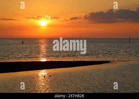 Golden sunset seen from River Wyre shore footpath at Knott End-on-Sea, Lancashire, looking out over River Wyre estuary at high tide on May 19th 2024. Stock Photo