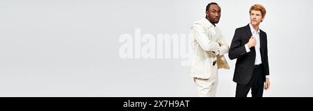 Two multicultural men in elegant attire stand together. Stock Photo