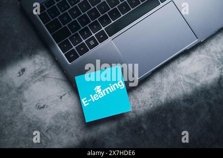 Blue adhesive note on laptop with online education concept. Distance education training and e-learning webinar on internet for personal development. Stock Photo