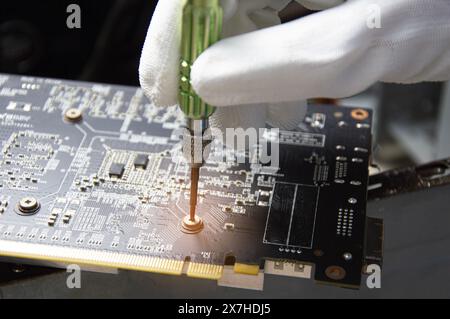 Technician who is repairing circuits, repairing graphics cards and computer parts. Stock Photo