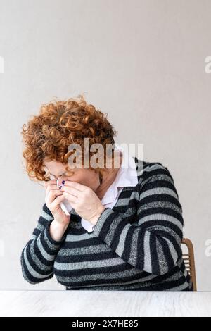 Side view of a woman  blowing her nose. Stock Photo