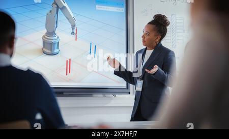 Black Teacher Explains Engineering to Students During University Robotics Lecture. She Uses Interactive Whiteboard. Group of Engineers Listen About Program Development for Robotic Arm in Classroom. Stock Photo
