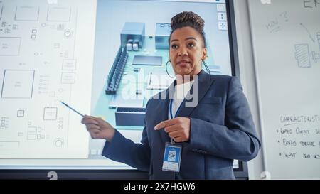 Black Female Teacher Uses Digital Interactive Whiteboard, Talks to Students and Shows 3D Computer Motherboard Components During Seminar. Intelligent Professor in Classroom Concept. Close Up. Stock Photo