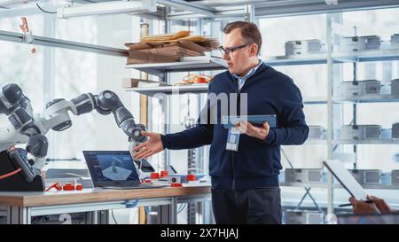 In Robotics Development Laboratory: Future Engineers and Scientists Work on Automated Robotic Arm Prototype. Professional Entrepreneur Inspires People For New Technological Achievements. Stock Photo