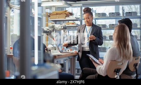 Team Meeting of Engineers Working on an Innovative More Efficient Ways of Robotic Arm Application. Group of Specialists Gathered Around Table, Solving Problems, Discussing Results. Stock Photo