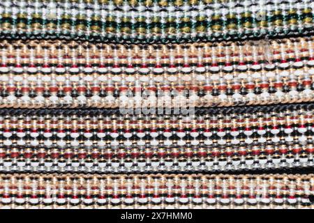 Woven multi-colored threads create a colorful, bright image of the braid .Braid - a narrow woven or braided strip or cord, usually having only 1 syste Stock Photo