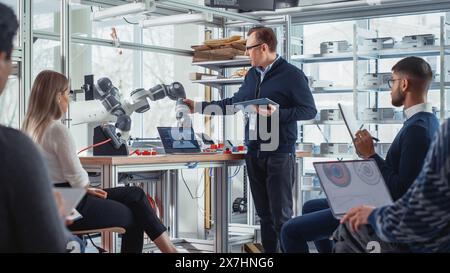 Chief Engineer Presents Innovative Robot Arm to Start-up Workers at Conference. Futuristic Design of AI Robot Hand That Helps to Automate Production Processes. Advanced Robotics Technology Concept. Stock Photo
