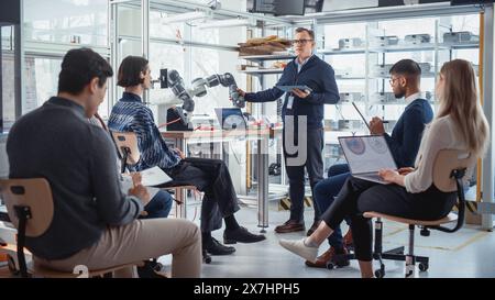 University Robotics Class: Teacher Explaining Engineering to Students by Using Robot Arm. Diverse Group of Young Engineers Programming Robotic Hand. Computer Science Higher Education Concept. Stock Photo
