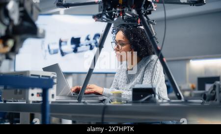 Concentrated Black Female Engineer Writing Code. Developing Software for Drone Control in the Research Center Laboratory. Technological Breakthrough in Flight Industries Concept. Stock Photo