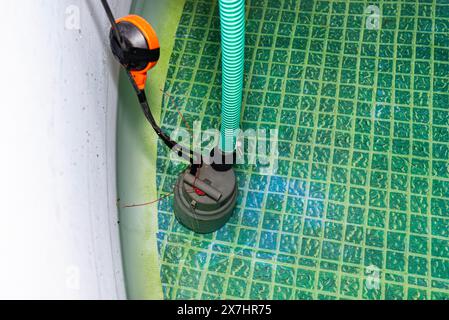 Emptying used water from a garden swimming pool using a home water pump ...