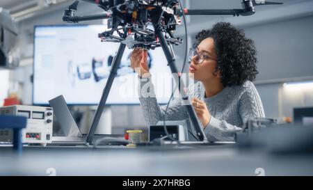 Concentrated Black Female Engineer Writing Code. Developing Software for Modern Drone Control in the Research Center Laboratory. Technological Breakthrough in Flight Industries Concept. Stock Photo