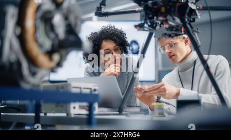 Diverse Engineers Discussing New Powerful Microchip to Put it Inside the Modern Drone. Technological Startup and Innovative Technologies in Unmanned Aerial Vehicle Concept. Stock Photo