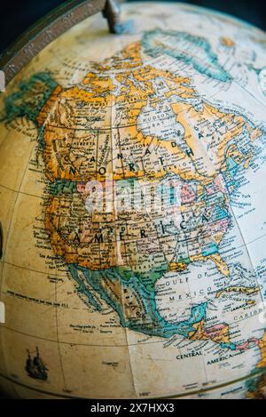 Vintage globe highlighting North America, South America and surrounding regions, featuring detailed map illustrations and historic design. Stock Photo