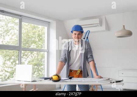 Male contractor working at table in room Stock Photo