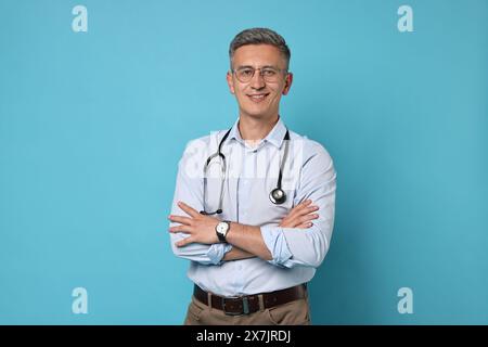 Doctor with stethoscope on light blue background Stock Photo