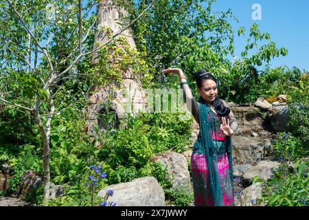 Chelsea, London, UK. 20th May, 2024. A Burmese dancer performs a traditional dance in costume and a floral head piece which includes flowers featured in the Burma Skincare Initiative Spirit of Partnership Sanctuary Garden at the RHS Chelsea Flower Show in London. Credit: Maureen McLean/Alamy Live News Stock Photo