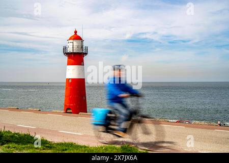 Nordseedeich bei Westkapelle, Leuchtturm Westkapelle Laag, Radfahrer auf dem Radweg Zeeuwse Wind Route, Provinz Zeeland, Halbinsel Walcheren, Niederlande, Radweg am Meer *** North Sea dike near Westkapelle, Westkapelle Laag lighthouse, cyclists on the Zeeuwse Wind Route cycle path, province of Zeeland, Walcheren peninsula, Netherlands, cycle path by the sea Stock Photo