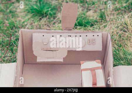 Toy cardboard plane in the field. Focus on the steering wheel Stock Photo