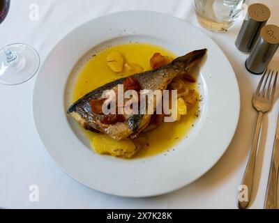 Grilled gilthead bream with stewed potato slices in sauce Stock Photo
