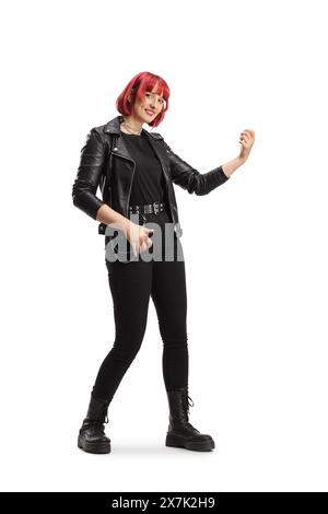 Cheerful young woman in a leather jacket pretending to play a guitar isolated on white background Stock Photo