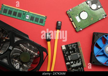 Graphics card and other computer hardware on red background, flat lay Stock Photo
