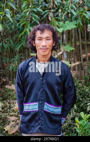 Portrait of a young man dressed in typical paj ntaub or flower cloth Hmong clothing, Chiang Khong, Chiang Rai province, northern Thailand Stock Photo