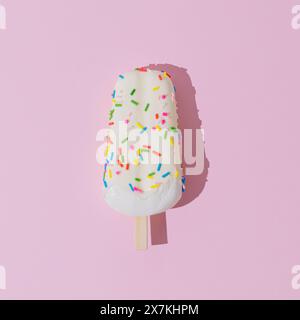 Colorful ice cream popsicle on light pastel pink background. Minimal summer concept. Ice cream aesthetic. Flat lay. Stock Photo