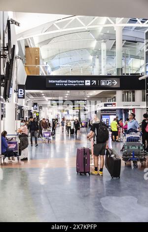 Auckland, New Zealand - February 21, 2024: Travelers inside at the Auckland International Airport. Stock Photo