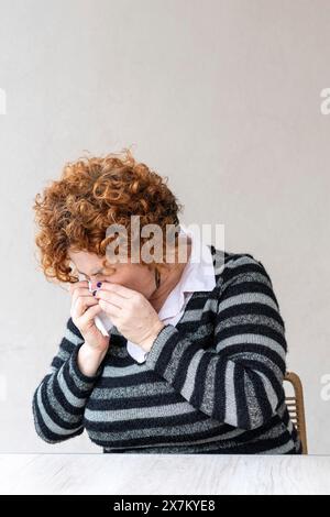 Side view of a woman blowing her nose Stock Photo