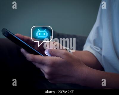 Artificial intelligence, AI chat bot technology concept. Glowing smart robot icon on speech bubble on mobile phone screen in hands, robot application Stock Photo