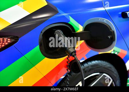 Electric Vehicle charging in station with power supply plugged into an electric car being charged. Stock Photo