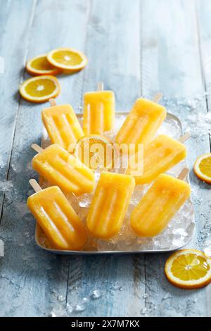 Homemade ice-cold orange popsicles on crushed ice Stock Photo