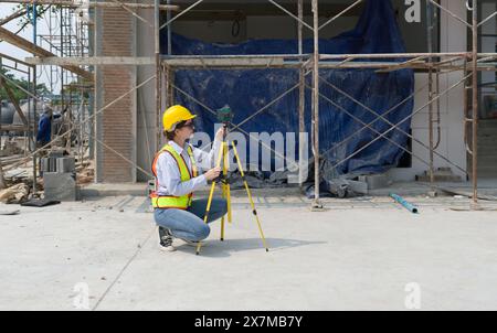 A construction worker is using a laser gauge to capture the setting of masonry, plastering and wall work at a building site. Stock Photo