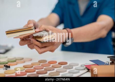 A close-up image of an interior designer or architect handing the color and material samples for the interior to someone during a meeting in the offic Stock Photo