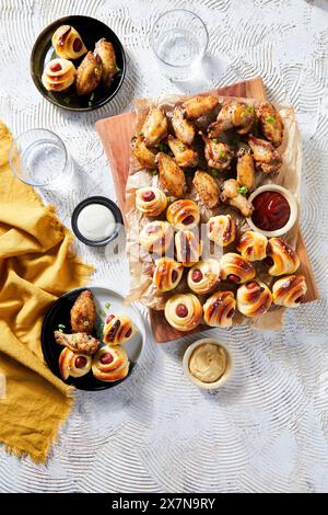 Game day food spread with chicken wings and pigs in a blanket. Stock Photo