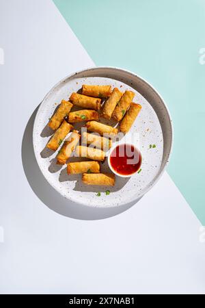 A Plate of Crispy Spring Rolls on a Pastel Backdrop Stock Photo