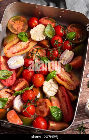 Fresh tomatoes, garlic, shallot, basil in baking pan Stock Photo