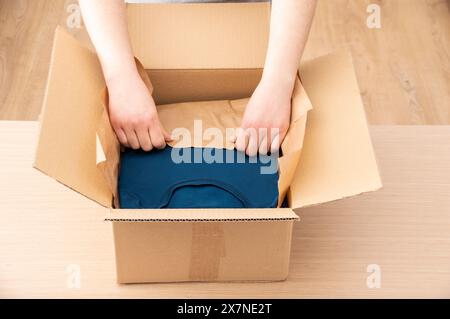 Close up view of women's online clothing store, small business owner seller entrepreneur packing package post shipping box preparing delivery parcel o Stock Photo