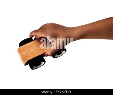 Child hand playing with miniature wooden toy cars,against a white background. Stock Photo