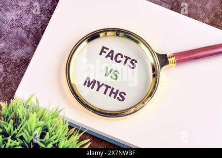Conceptual symbol. Copy space. Facts vs myths words written through a magnifying glass on a blank sheet of notepad Stock Photo