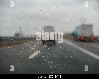 Piacenza, Italy -April 22nd 2024 A highway scene under an overcast sky featuring cars and trucks with road signs and an overpass, rainy day on Motorwa Stock Photo