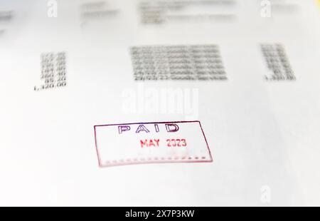 An accounting concept with close up of a business invoice stamped with the word paid. Stock Photo