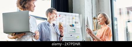 Multicultural team of hardworking businesswomen collaborating in front of whiteboard in office. Stock Photo