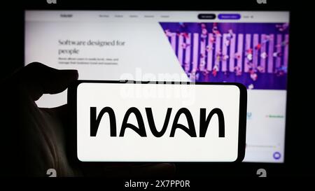 Person holding cellphone with logo of US travel management software company Navan Inc. in front of business webpage. Focus on phone display. Stock Photo