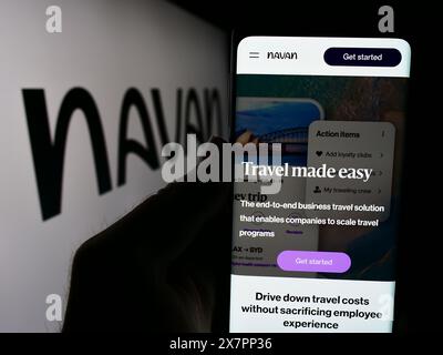 Person holding cellphone with webpage of US travel management software company Navan Inc. in front of logo. Focus on center of phone display. Stock Photo