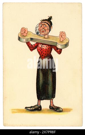 Original and cruel early 1900's WW1 era anti-suffragette comic cartoon postcard after illustrator Dudley Buxton,  of  unattractive woman in stocks. with a metal cage / mask over her face, being silenced. Misogynistic imagery.  Possibly German, circa 1916 Stock Photo
