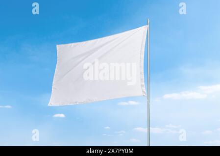 White flag with clean texture against a vibrant blue sky, perfect for flag mockups or presentations Stock Photo